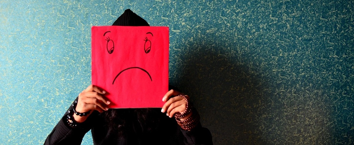 Anxiety symptoms observed in a child afraid of being seen by others and hiding behind paper cover, anxiety vs stress
