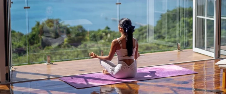 Young adult practicing mindfulness with yoga mat and sunlight, representing strategies on how to improve mental health